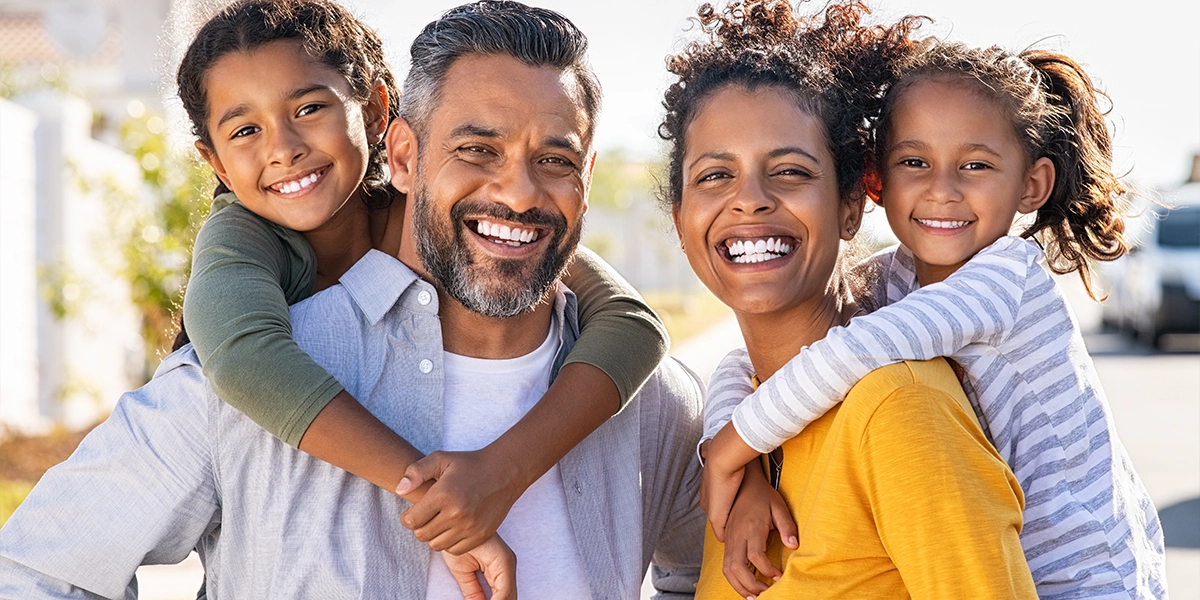 Multiethnic parents giving children piggyback ride
