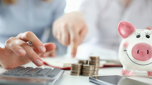 Man and woman in their forties using a calculator to maximize their retirement savings.