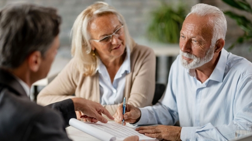 Senior couple signing a contract while having a meeting with Estate Planning attorney in the office