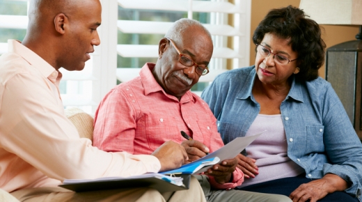 Estate Planning Attorney Talking To Senior Couple At Home